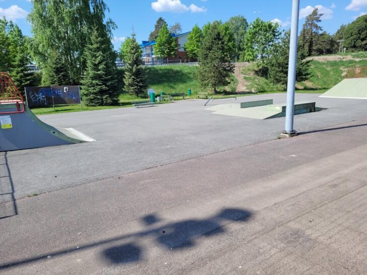 Kankaan skeittipuisto, jossa asfaltoidulla pinnalla on ramppeja ja kaiteita. Taustalla on puustoa ja näkymä Karjalankadun suuntaan. 